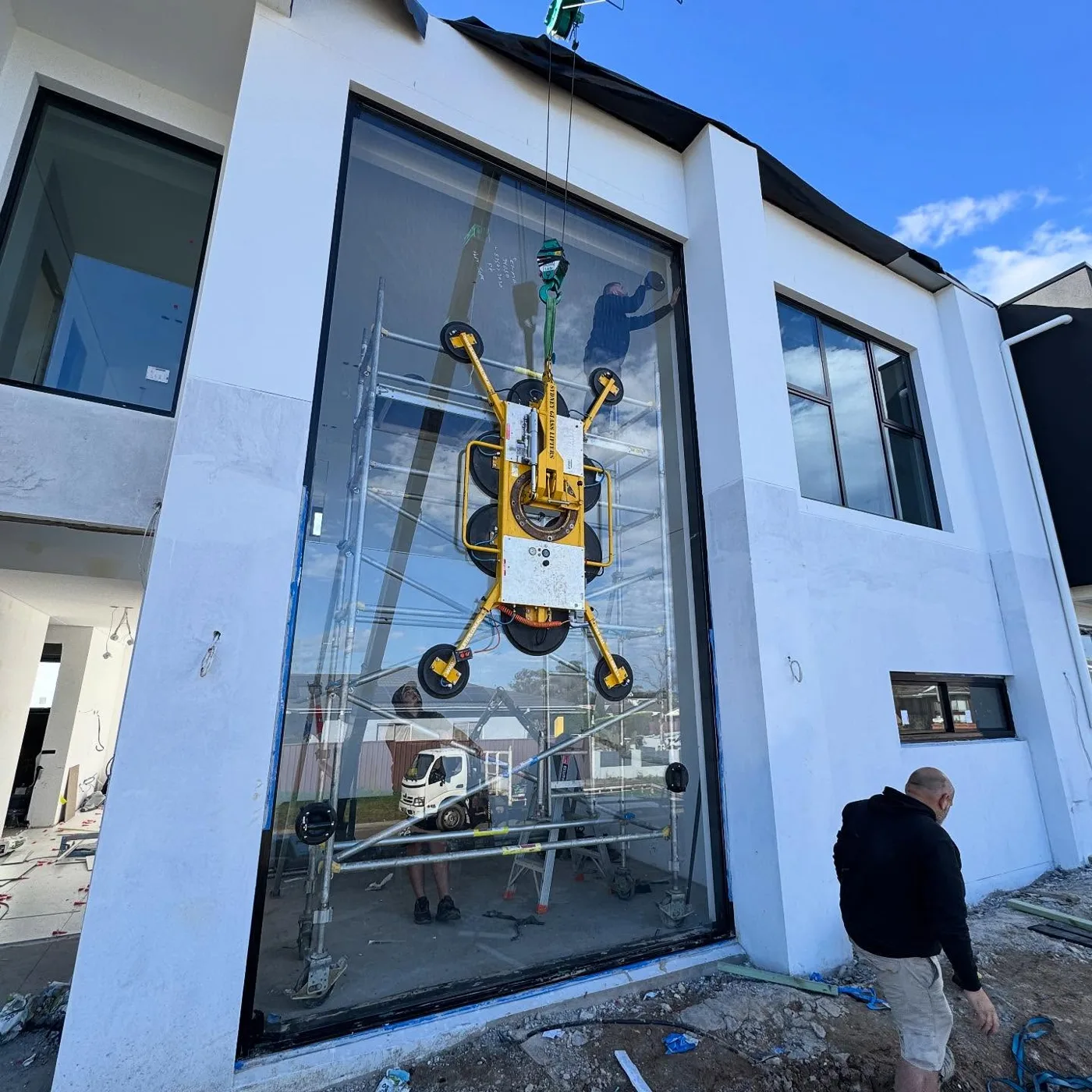 Crane vacuum lifter installing a large glass panel into a new two storey home - AGM Windows & Doors, Sydney