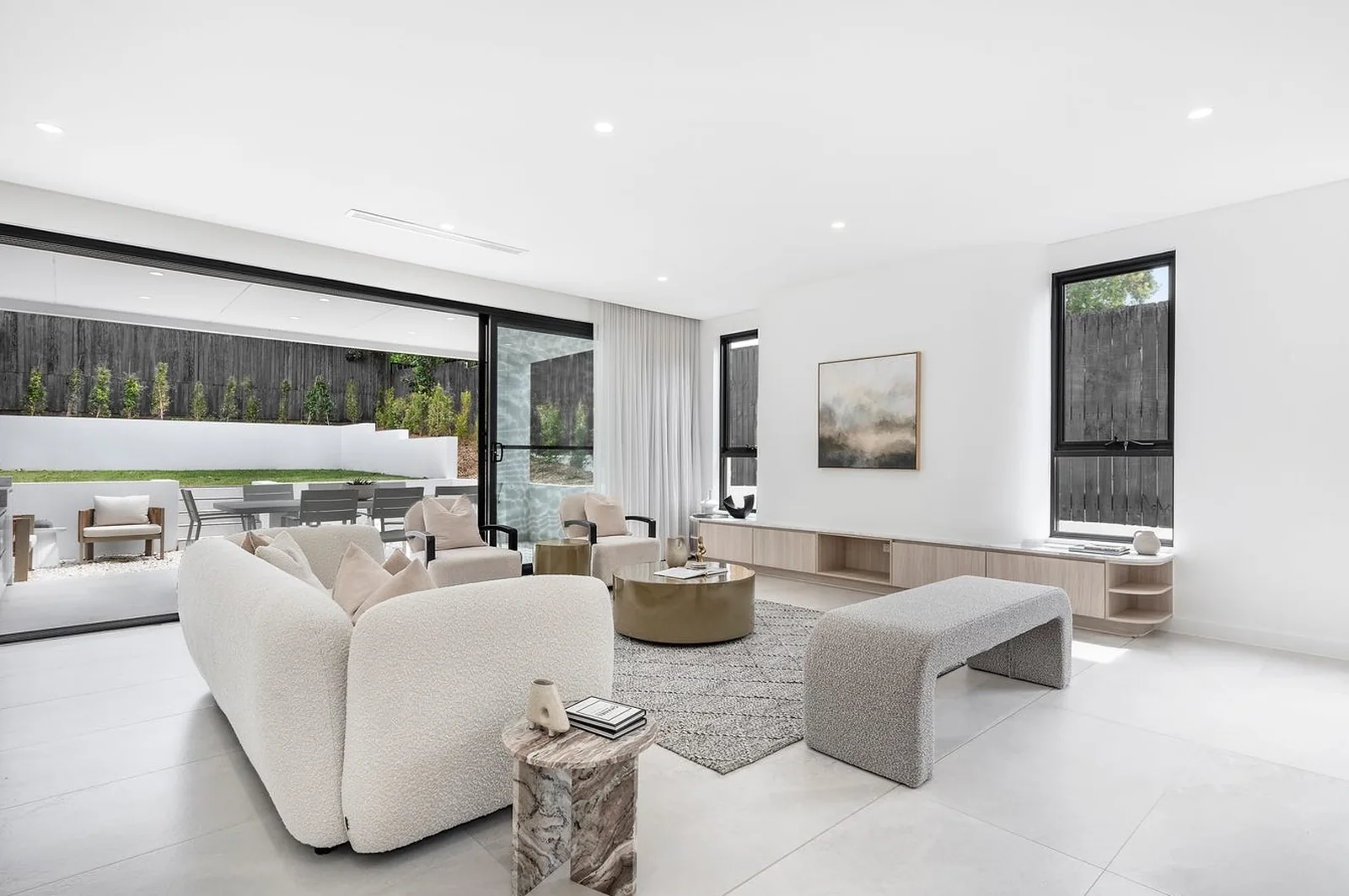 Open plan living room with black aluminium windows and wide sliding doors to a terrace - AGM Windows & Doors, Sydney