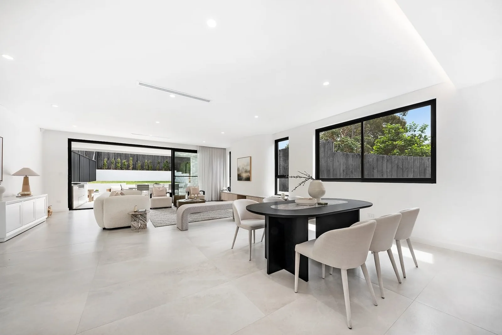 Dining and living area with black aluminium windows and sliding doors to a courtyard - AGM Windows & Doors, Sydney