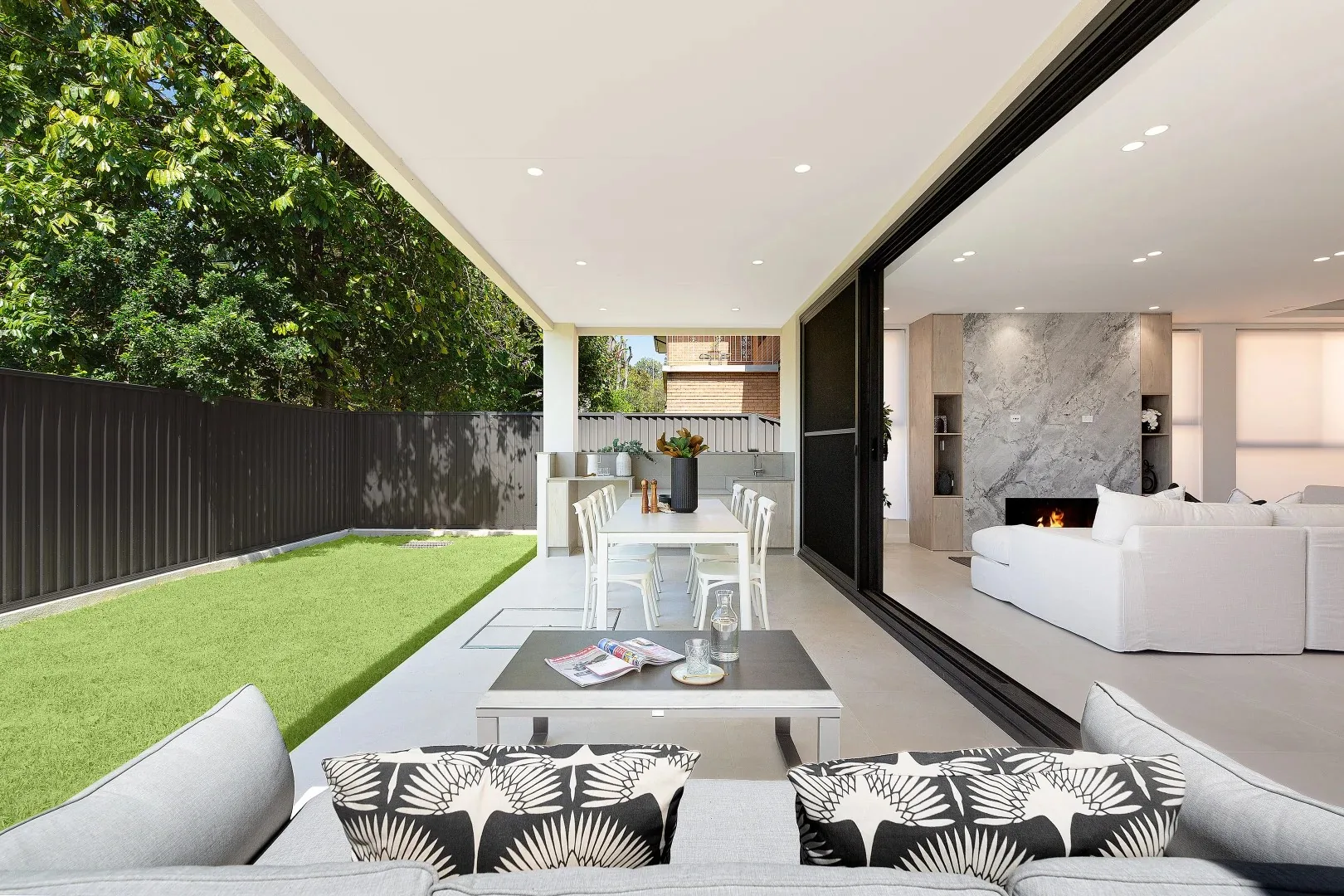 Full-height aluminium sliding glass wall opening a Sydney living room onto the lawn