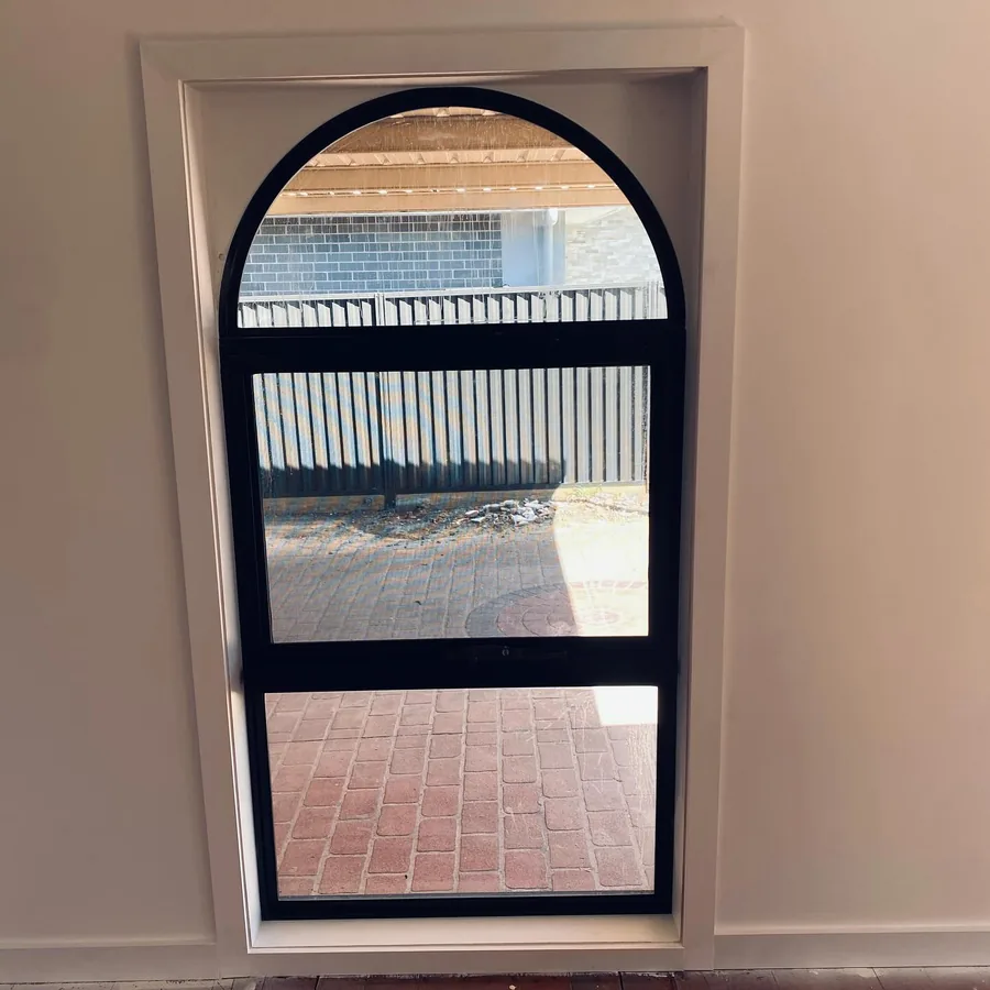 Arched aluminium window viewed from inside a Sydney home