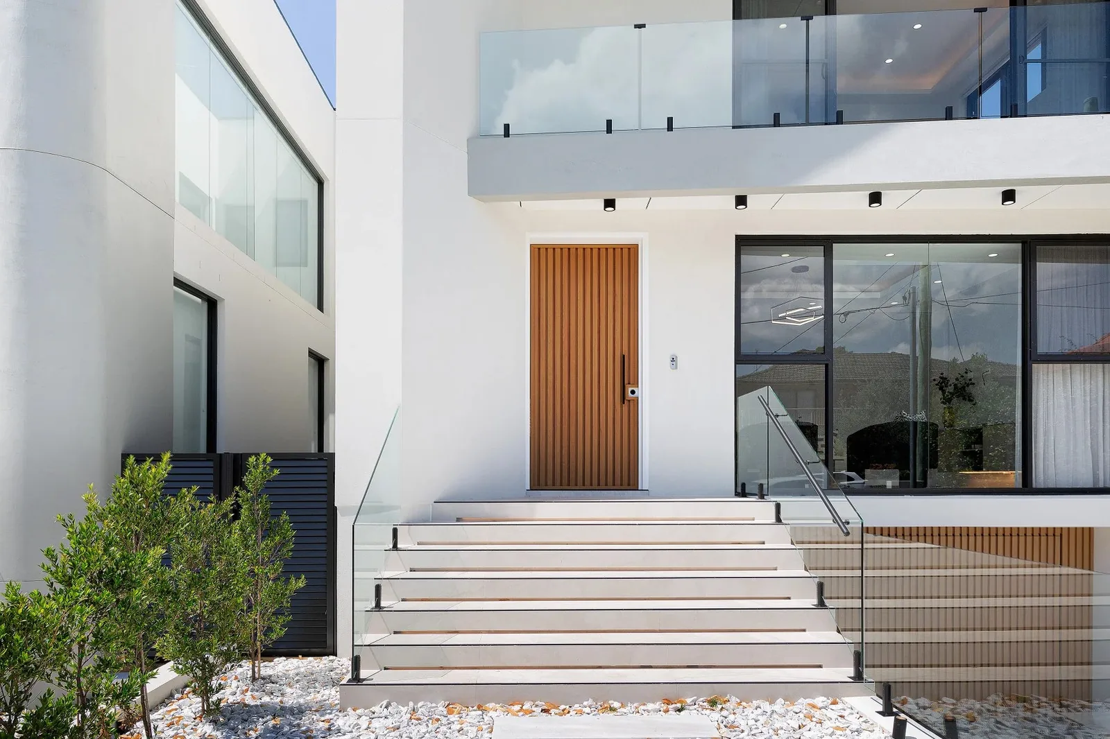 Glazed entry facade with a timber front door and glass stair wall - AGM Windows & Doors, Sydney