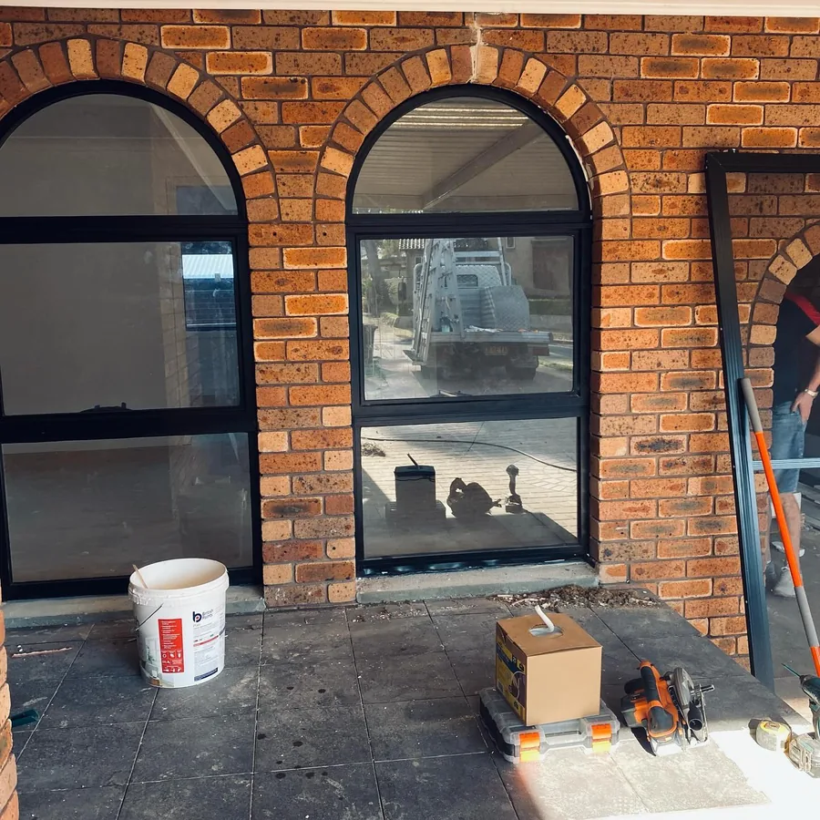 Arched aluminium window set into a brick facade in Sydney