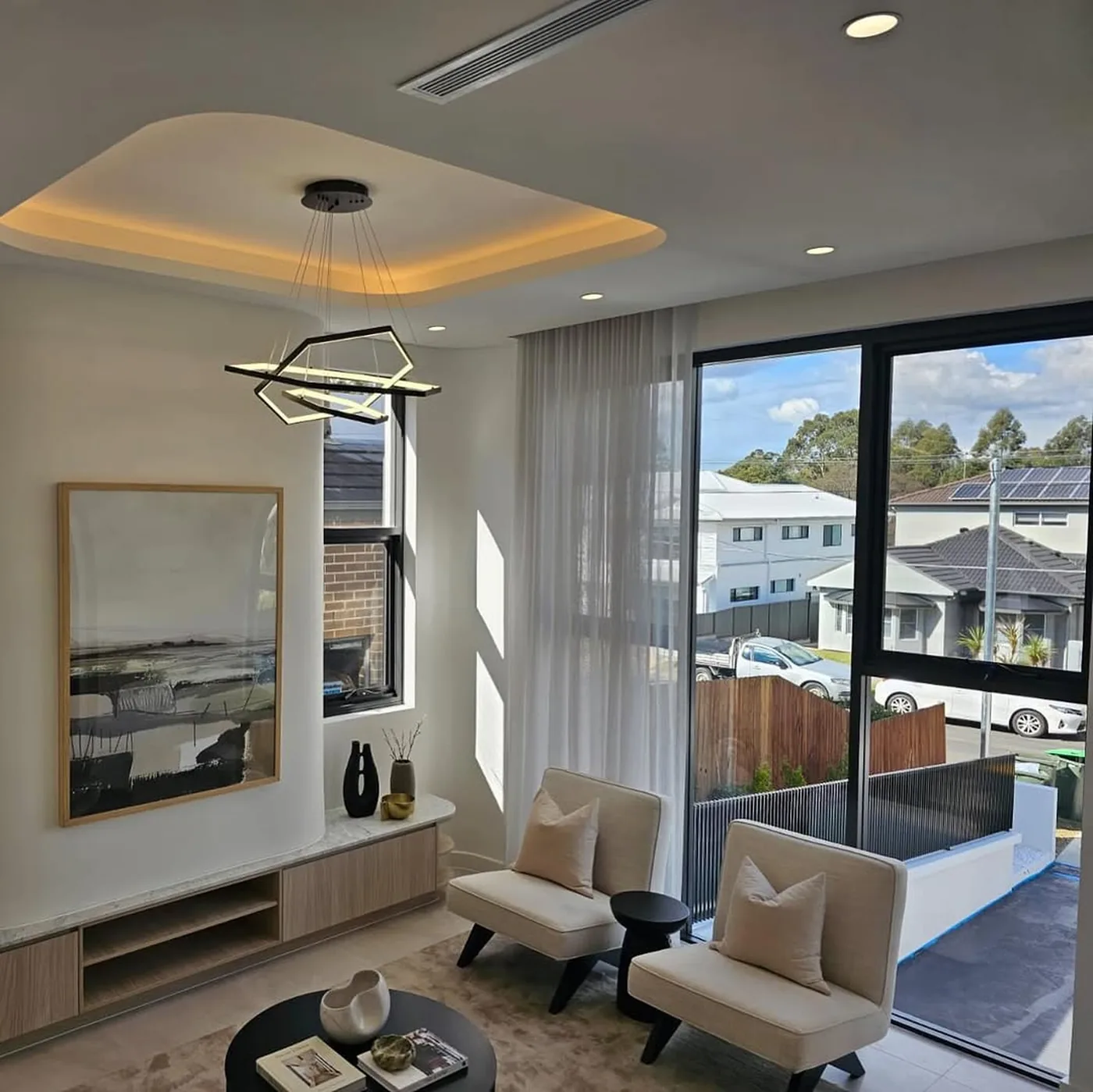 Living area with large black aluminium windows and sliding door to a driveway - AGM Windows & Doors, Sydney