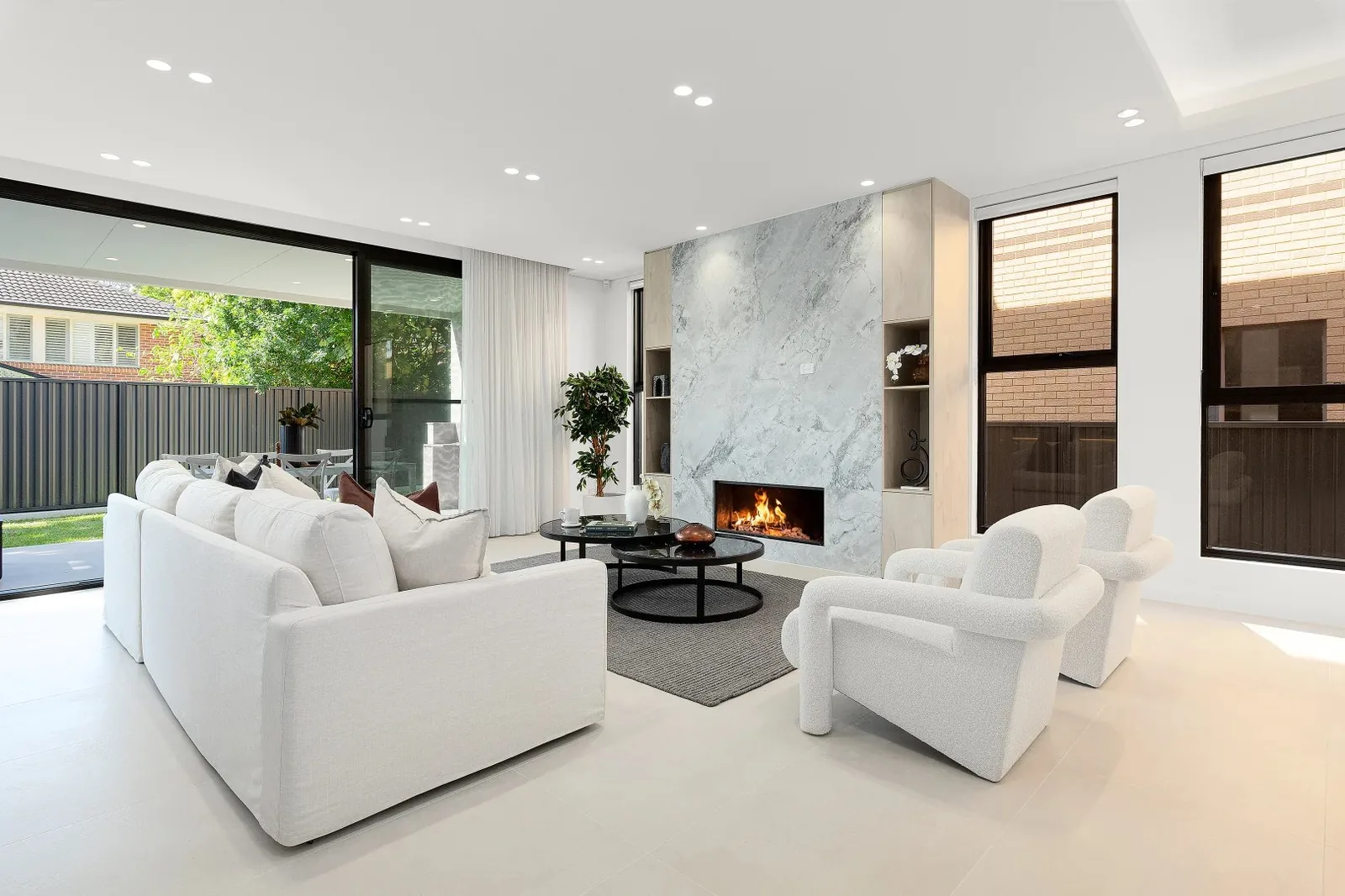 Modern living room with sliding doors opening to a paved outdoor area - AGM Windows & Doors, Sydney